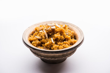 Wheat Laapsi/Lapsi/Shira/Halwa is an Indian sweet dish made of broken wheat or Daliya pieces and ghee along with nuts, raisins and dried fruits. It's a healthy food. served in a bowl, selective focus