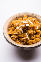 Wheat Laapsi/Lapsi/Shira/Halwa is an Indian sweet dish made of broken wheat or Daliya pieces and ghee along with nuts, raisins and dried fruits. It's a healthy food. served in a bowl, selective focus
