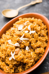 Wheat Laapsi/Lapsi/Shira/Halwa is an Indian sweet dish made of broken wheat or Daliya pieces and ghee along with nuts, raisins and dried fruits. It's a healthy food. served in a bowl, selective focus