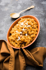 Wheat Laapsi/Lapsi/Shira/Halwa is an Indian sweet dish made of broken wheat or Daliya pieces and ghee along with nuts, raisins and dried fruits. It's a healthy food. served in a bowl, selective focus