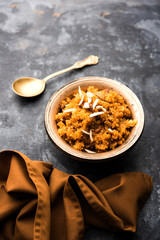 Wheat Laapsi/Lapsi/Shira/Halwa is an Indian sweet dish made of broken wheat or Daliya pieces and ghee along with nuts, raisins and dried fruits. It's a healthy food. served in a bowl, selective focus