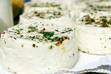 Large selection of cheese varieties on a wooden table background.