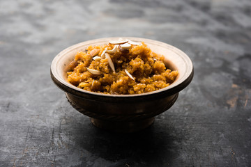 Wheat Laapsi/Lapsi/Shira/Halwa is an Indian sweet dish made of broken wheat or Daliya pieces and ghee along with nuts, raisins and dried fruits. It's a healthy food. served in a bowl, selective focus
