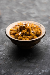 Wheat Laapsi/Lapsi/Shira/Halwa is an Indian sweet dish made of broken wheat or Daliya pieces and ghee along with nuts, raisins and dried fruits. It's a healthy food. served in a bowl, selective focus