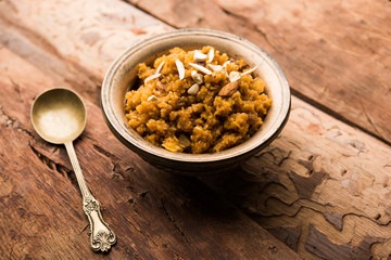 Wheat Laapsi/Lapsi/Shira/Halwa is an Indian sweet dish made of broken wheat or Daliya pieces and ghee along with nuts, raisins and dried fruits. It's a healthy food. served in a bowl, selective focus