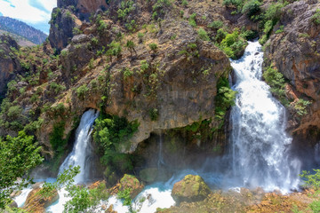 Fototapeta na wymiar Kapuzbasi Waterfall in Aladaglar National Park Green trees round the waterfall soups composition.