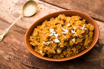 Wheat Laapsi/Lapsi/Shira/Halwa is an Indian sweet dish made of broken wheat or Daliya pieces and ghee along with nuts, raisins and dried fruits. It's a healthy food. served in a bowl, selective focus