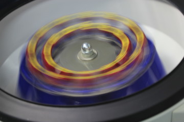 The centrifuge rotates with red vacuums in the laboratory.