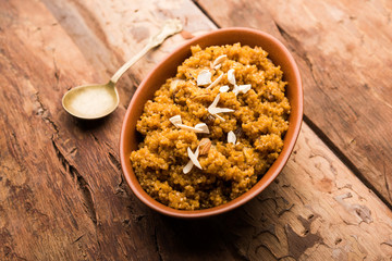 Wheat Laapsi/Lapsi/Shira/Halwa is an Indian sweet dish made of broken wheat or Daliya pieces and ghee along with nuts, raisins and dried fruits. It's a healthy food. served in a bowl, selective focus