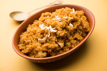 Wheat Laapsi/Lapsi/Shira/Halwa is an Indian sweet dish made of broken wheat or Daliya pieces and ghee along with nuts, raisins and dried fruits. It's a healthy food. served in a bowl, selective focus