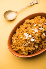 Wheat Laapsi/Lapsi/Shira/Halwa is an Indian sweet dish made of broken wheat or Daliya pieces and ghee along with nuts, raisins and dried fruits. It's a healthy food. served in a bowl, selective focus
