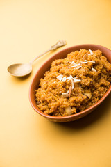 Wheat Laapsi/Lapsi/Shira/Halwa is an Indian sweet dish made of broken wheat or Daliya pieces and ghee along with nuts, raisins and dried fruits. It's a healthy food. served in a bowl, selective focus