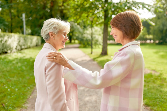 Old Age, Retirement And People Concept - Two Senior Women Or Friends Talking At Summer Park