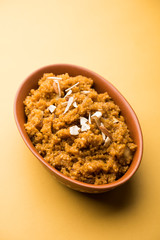 Wheat Laapsi/Lapsi/Shira/Halwa is an Indian sweet dish made of broken wheat or Daliya pieces and ghee along with nuts, raisins and dried fruits. It's a healthy food. served in a bowl, selective focus