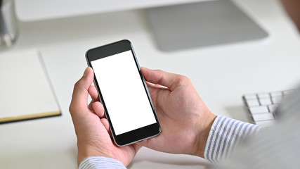 Cropped shot man using mockup smartphone on table office.