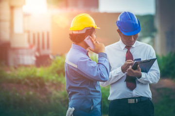 Chief project engineer and construction supervisor and consultants are using smartphones to communicate with labor contractors, project owners. They were in the zone which is building a large building