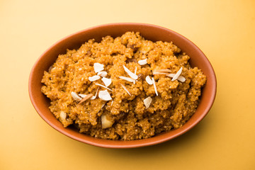 Wheat Laapsi/Lapsi/Shira/Halwa is an Indian sweet dish made of broken wheat or Daliya pieces and ghee along with nuts, raisins and dried fruits. It's a healthy food. served in a bowl, selective focus