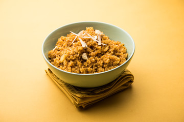 Wheat Laapsi/Lapsi/Shira/Halwa is an Indian sweet dish made of broken wheat or Daliya pieces and ghee along with nuts, raisins and dried fruits. It's a healthy food. served in a bowl, selective focus