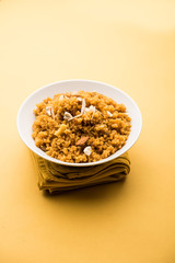 Wheat Laapsi/Lapsi/Shira/Halwa is an Indian sweet dish made of broken wheat or Daliya pieces and ghee along with nuts, raisins and dried fruits. It's a healthy food. served in a bowl, selective focus