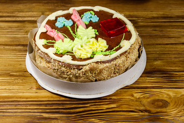 Kiev cake with cream, nuts and meringue in cardboard box on wooden table