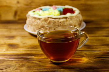 Cup of tea and Kiev cake on a wooden table