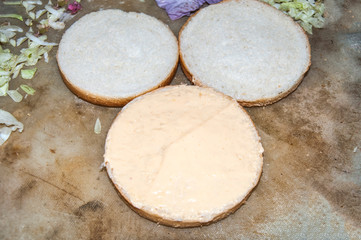 Sauce coated Burger bun breads on wooden background