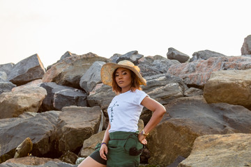 Young African lady posing by rocks on the beach