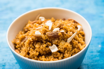 Wheat Laapsi/Lapsi/Shira/Halwa is an Indian sweet dish made of broken wheat or Daliya pieces and ghee along with nuts, raisins and dried fruits. It's a healthy food. served in a bowl, selective focus