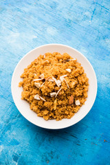 Wheat Laapsi/Lapsi/Shira/Halwa is an Indian sweet dish made of broken wheat or Daliya pieces and ghee along with nuts, raisins and dried fruits. It's a healthy food. served in a bowl, selective focus