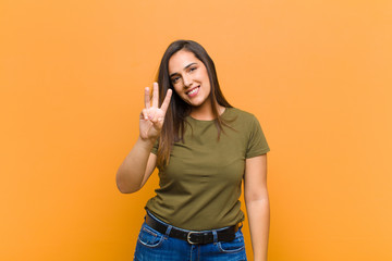 young pretty woman smiling and looking friendly, showing number three or third with hand forward,...