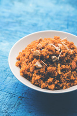 Wheat Laapsi/Lapsi/Shira/Halwa is an Indian sweet dish made of broken wheat or Daliya pieces and ghee along with nuts, raisins and dried fruits. It's a healthy food. served in a bowl, selective focus