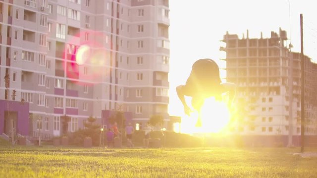healthy man training back flip exercise intense muscle workout muscular bodybuilder doing superman enjoying extreme fitness routine in city park slow motion.