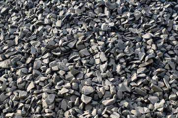 Industrial background with pile of gravel. Extraction of gravel. Construction of roads. Piles of gravel on construction site.