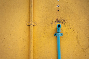 yellow wall with blue pipe
