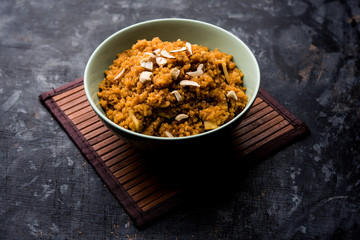 Wheat Laapsi/Lapsi/Shira/Halwa is an Indian sweet dish made of broken wheat or Daliya pieces and ghee along with nuts, raisins and dried fruits. It's a healthy food. served in a bowl, selective focus