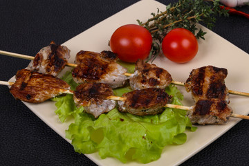 Pork kebab skewers in the plate with salad leaves and tomatoes