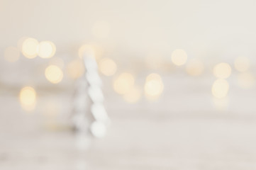 Blurred background with small christmas tree and yellow lights. Festive season