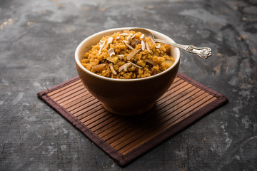 Wheat Laapsi/Lapsi/Shira/Halwa is an Indian sweet dish made of broken wheat or Daliya pieces and ghee along with nuts, raisins and dried fruits. It's a healthy food. served in a bowl, selective focus