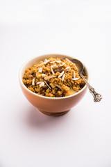 Wheat Laapsi/Lapsi/Shira/Halwa is an Indian sweet dish made of broken wheat or Daliya pieces and ghee along with nuts, raisins and dried fruits. It's a healthy food. served in a bowl, selective focus