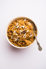 Wheat Laapsi/Lapsi/Shira/Halwa is an Indian sweet dish made of broken wheat or Daliya pieces and ghee along with nuts, raisins and dried fruits. It's a healthy food. served in a bowl, selective focus
