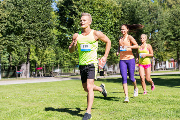 fitness, sport, race and healthy lifestyle concept - group of happy people or sportsmen running...