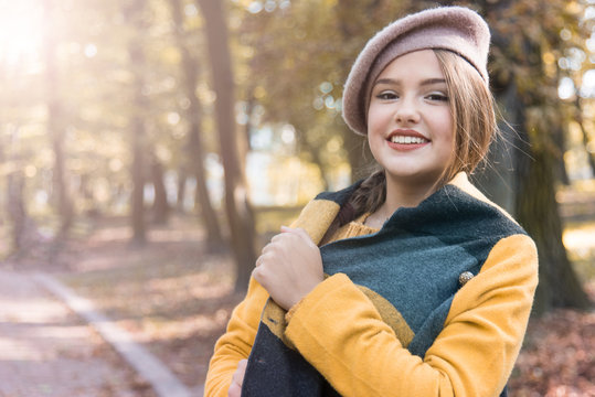 Young beautiful woman in autumn park. Emotions, people, beauty and lifestyle concept. Cope space. Street photo of young woman wearing stylish classic clothes. Female fashion concept. French style.