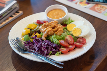 Shrimp salad with green lettuce, tomatoes, herbs and olive oil, lemon salad dressing, healthy food.