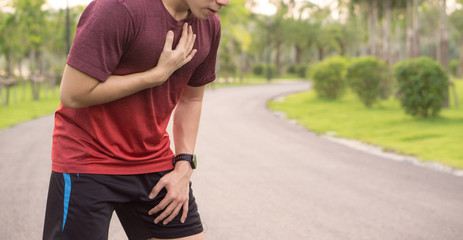 Sport man having heart attack or chest pain after running workout at park. Sport and Health care...