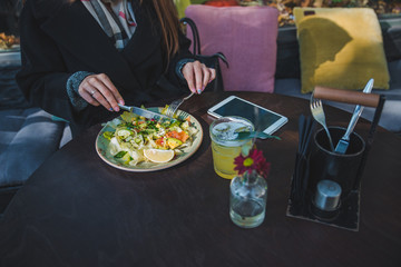 woman in cafe eating salad hands close up no face