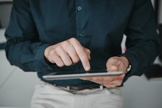 Midsection of businessman wearing shirt touching blank screen digital tablet with finger