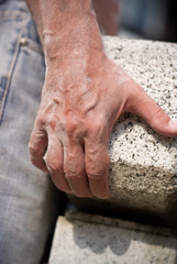 hands holding granite stone