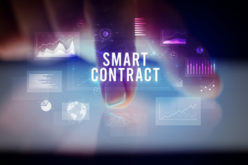 Finger touching tablet with charts and SMART CONTRACT inscription, business concept