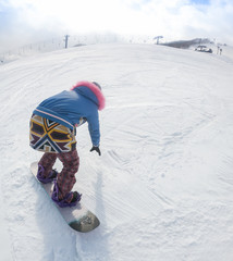 Views of Mount Fuji in Japan . Free ride snowboarder downhill on a snow-covered slope leaving behind mountains against the blue sky . Winter vacation and sport concept