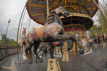 Riding around a horses carousel in autumn day